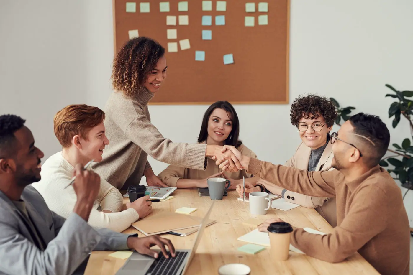 Team shaking hands across a meeting table