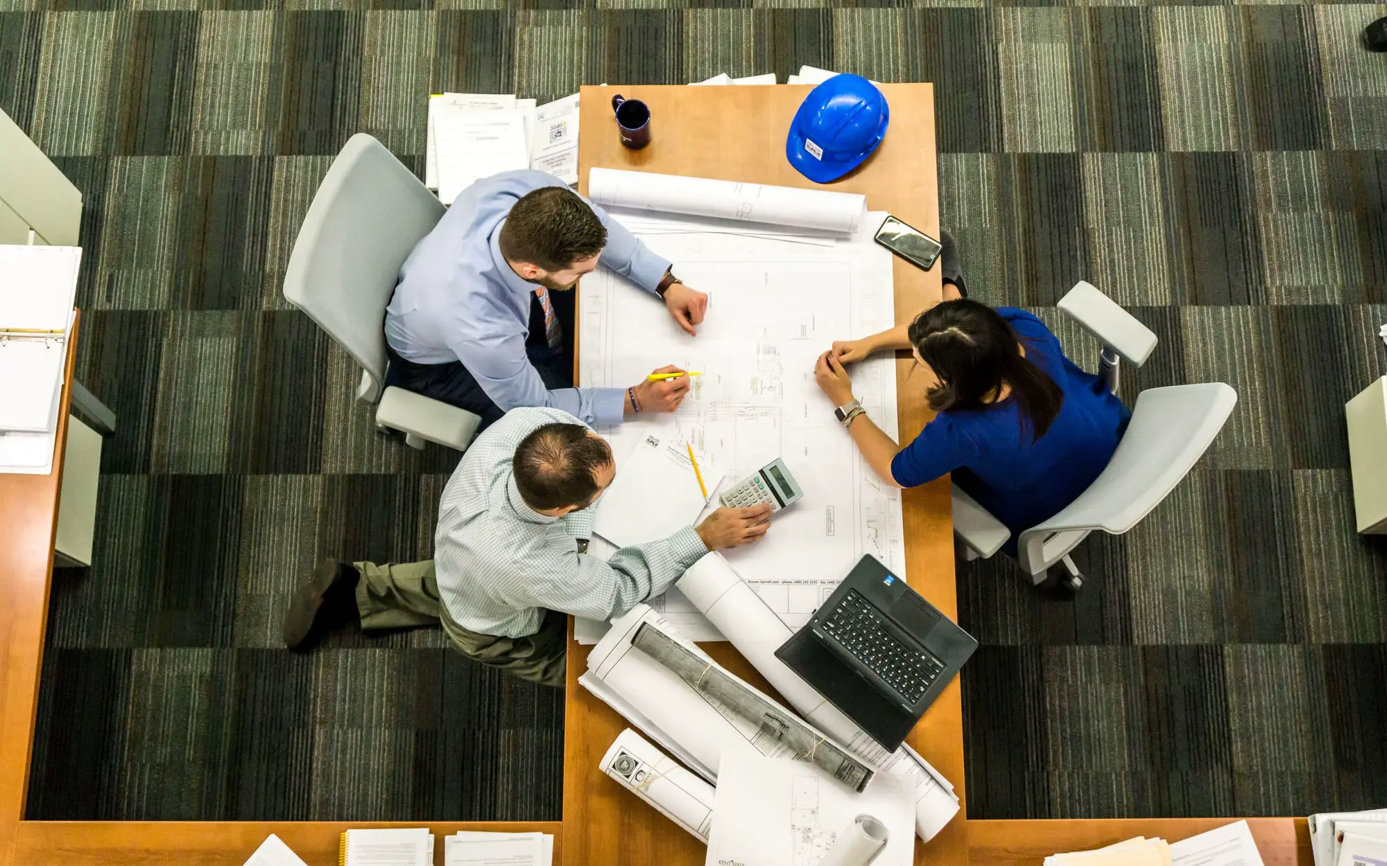 Team planning a project around printed plans
