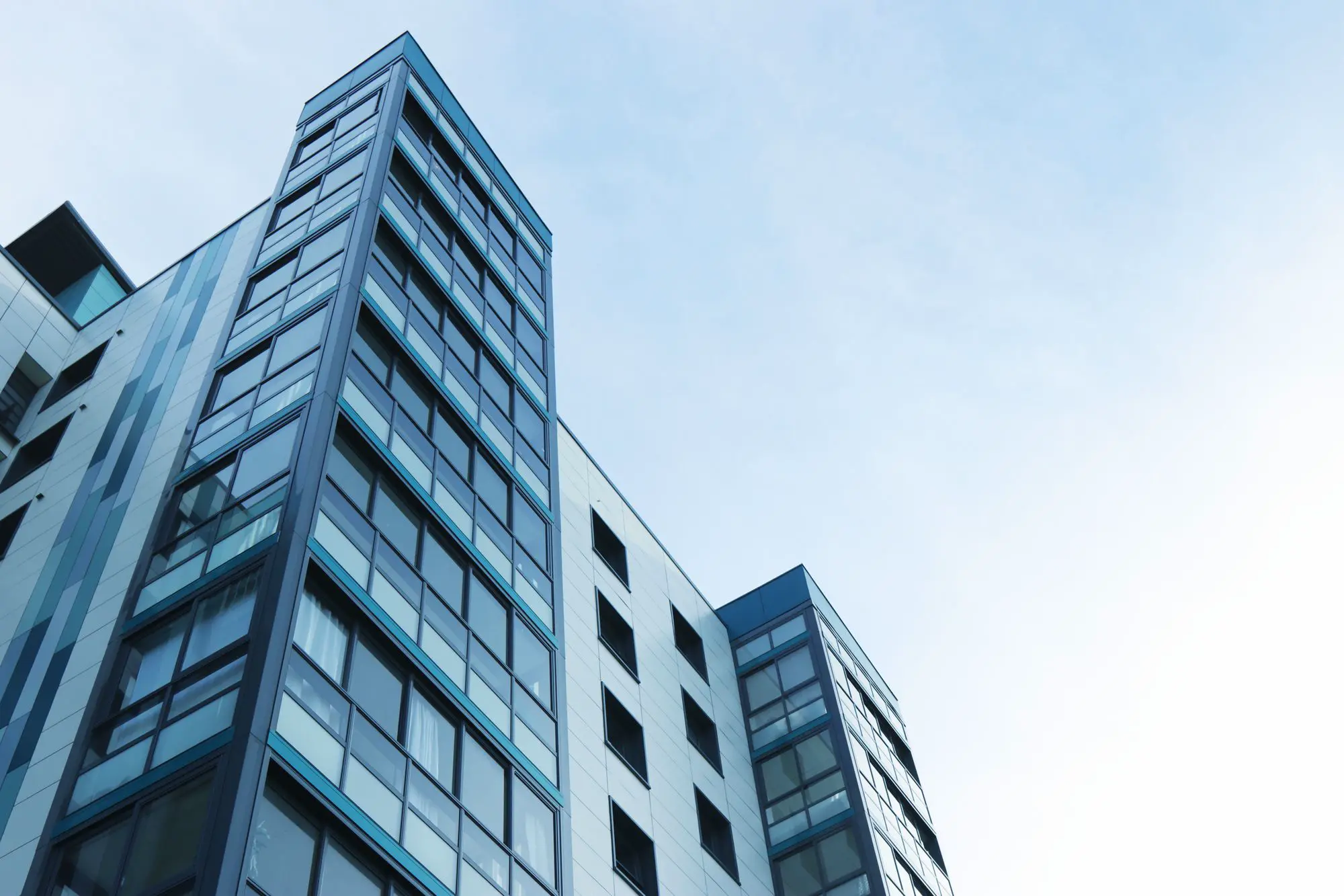 Glass office tower against a blue sky